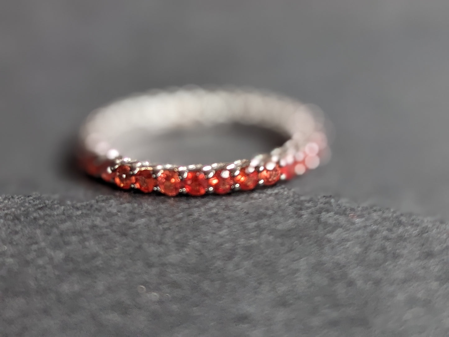 White gold & burnt orange sapphire eternity band 18k